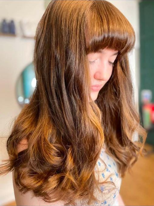 Warm brunette with a full fringe